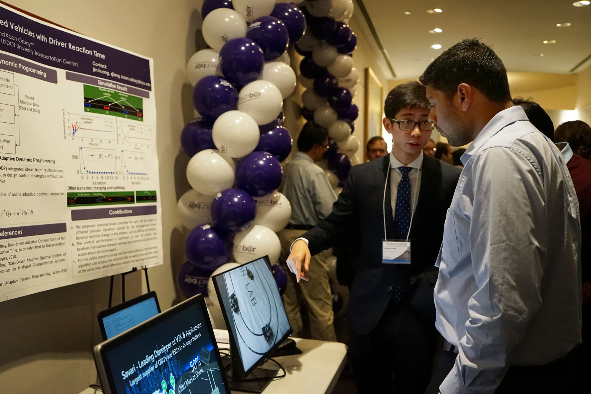 NYU Tandon PhD candidate Mengzhe Huang explains some of the recent research on display to a symposium attendee.