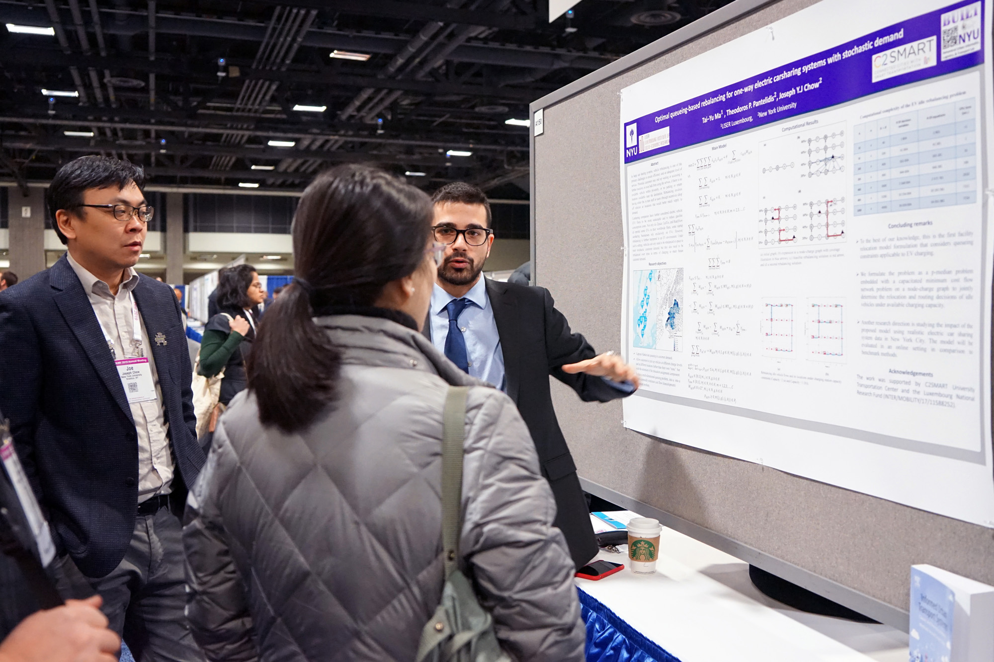 Professor Joseph Chow and graduate student Ted Pantelidis discuss a research poster with conference attendees.