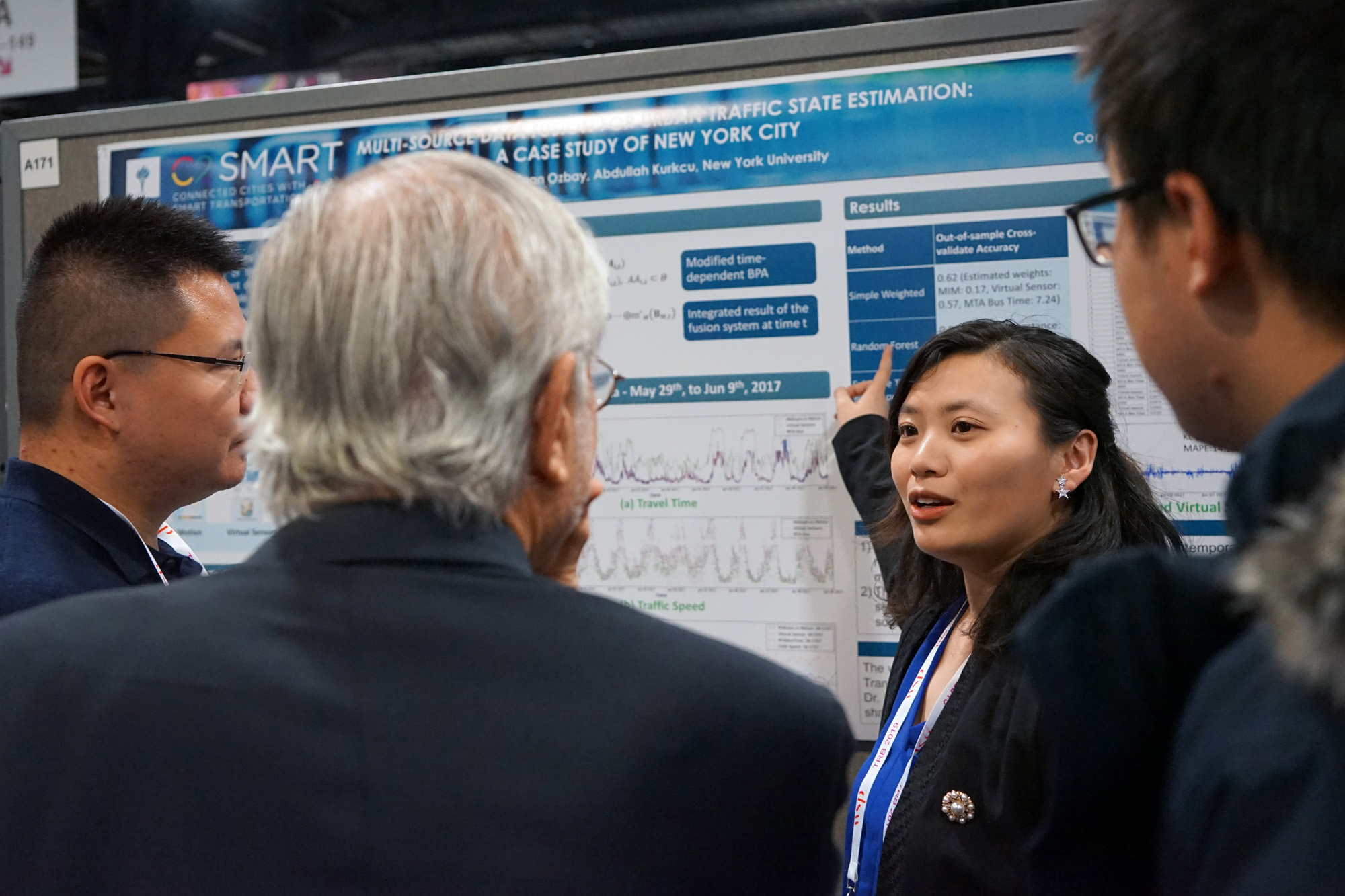 Graduate student Jingqin Gao answers questions about her research poster from conference attendees.
