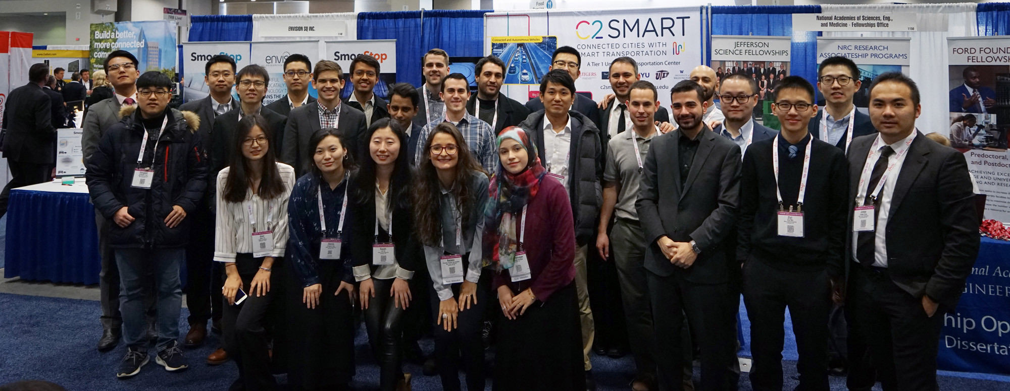 Graduate students attending TRB from Professor Kaan Ozbay's and Joseph Chow's labs pose for a group photo at C2SMART's booth in the Exhibit Hall.