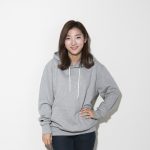 Photo of a woman in a gray sweatshirt in front of a white background